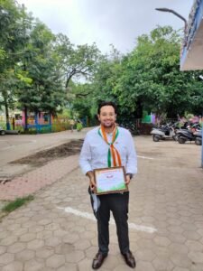 Dr. Varchasvi Mudgal with colleagues, receiving a document or gift in an office setting.