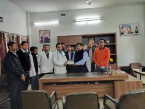 Group photo of Dr. Varchasvi Mudgal with colleagues and clients in an office setting.