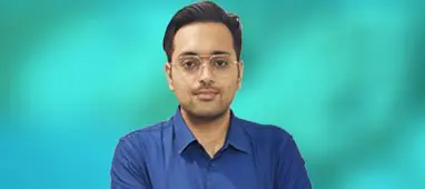 Dr. Varchasvi Mudgal, a psychiatrist, standing confidently with a blue background.