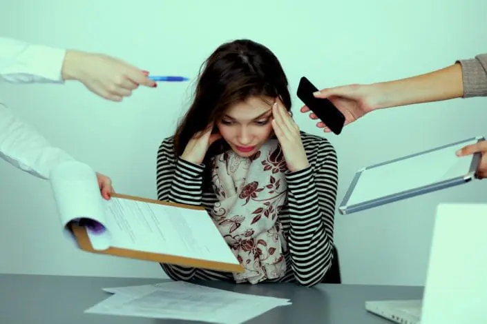 "Young woman experiencing stress due to multitasking, overwhelmed with work, anxiety, and pressure."