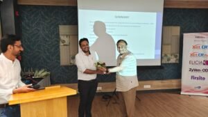 "Dr. Varchasvi Mudgal receives a bouquet from a senior colleague during a medical seminar.