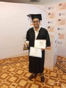 "Dr. Varchasvi Mudgal holding an award and certificate at a graduation ceremony."